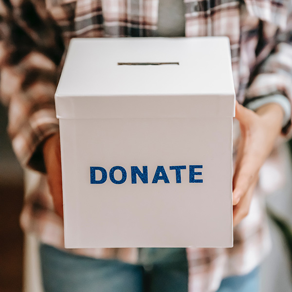 Person holding a box that says donate.